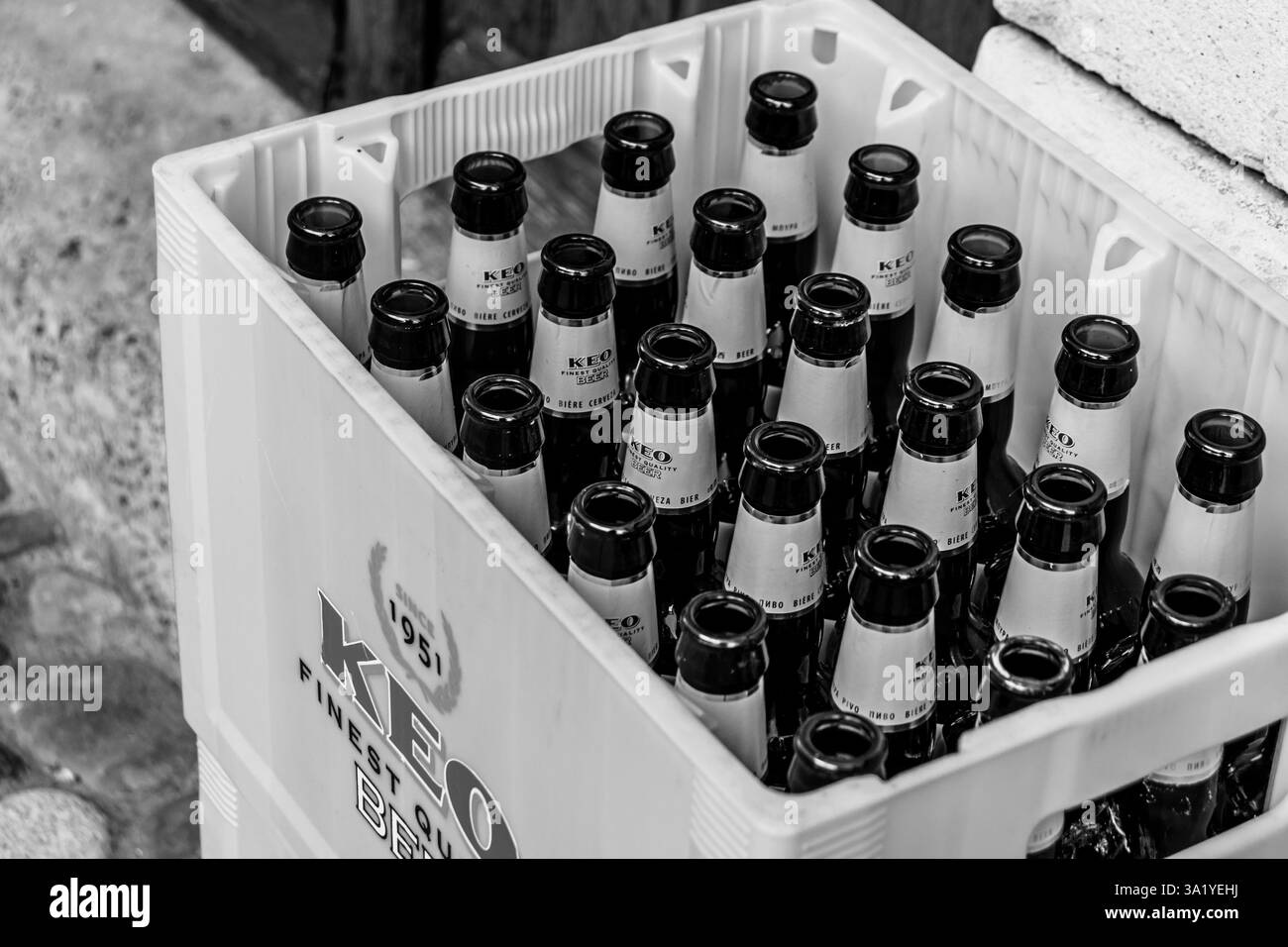 Limassol, Cipro - 20 dicembre 2025: Birra KEO bianca e nera bottiglie di vetro vuote in cassa Foto Stock