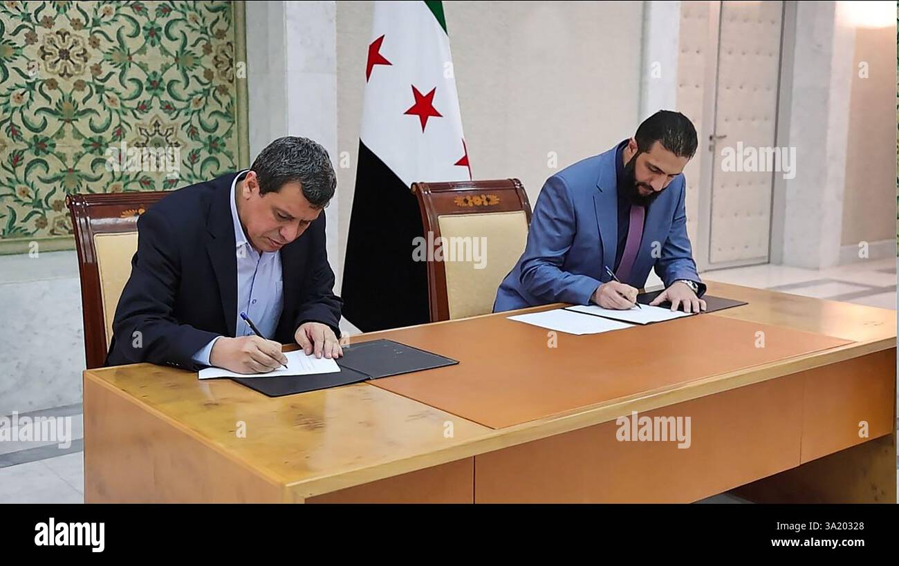 il presidente ad interim della Siria Ahmed al-Sharaa (R) e il comandante in capo delle forze democratiche siriane (SDF) Mazloum Abdi firmano un accordo per integrare le istituzioni dell'amministrazione curda semi-autonoma nel nord-est nel governo nazionale, nella capitale siriana Damasco il 10 marzo 2025. Foto della Syrian Arab News Agency (sana)/UPI Credit: UPI/Alamy Live News Foto Stock