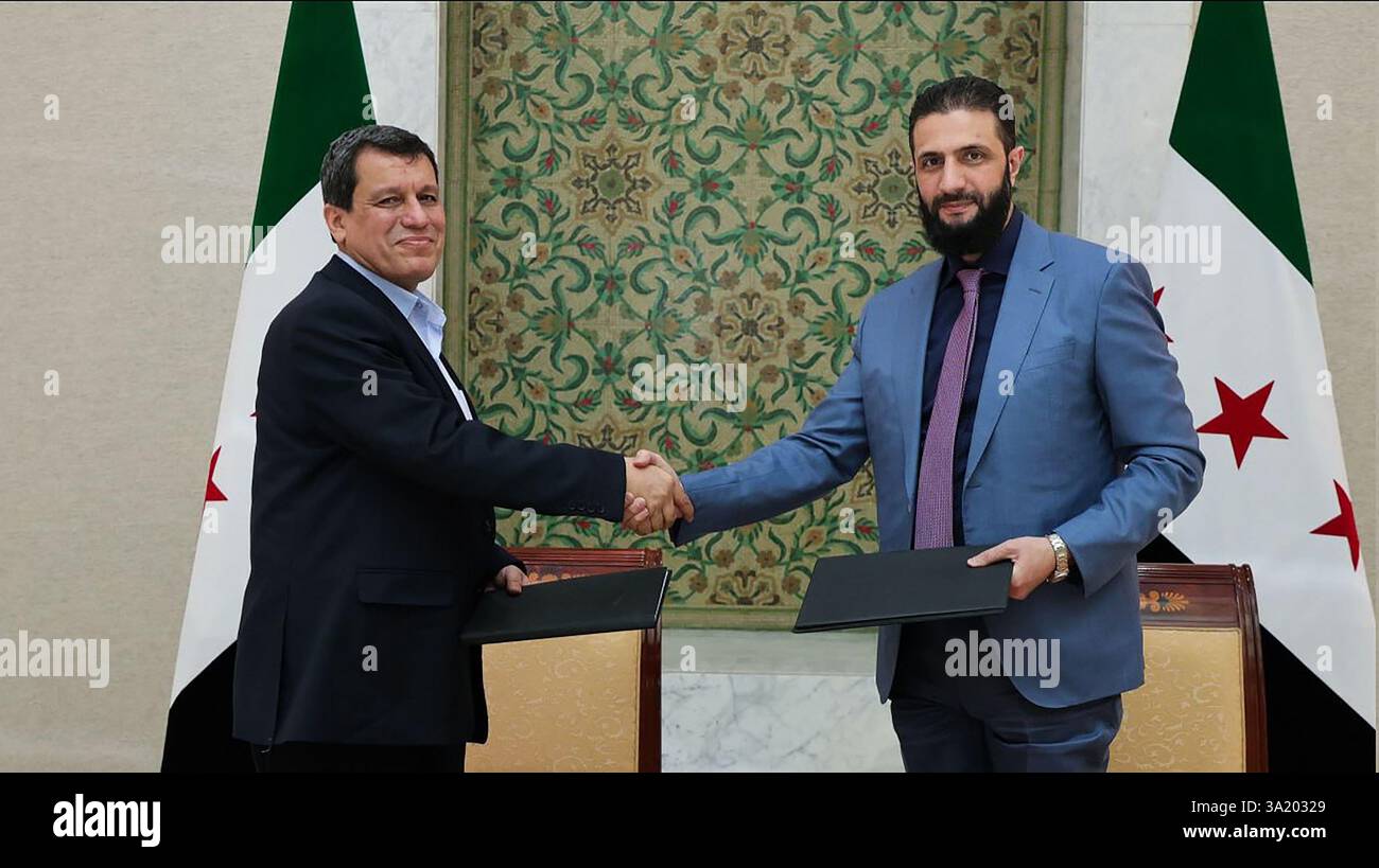 il presidente ad interim della Siria Ahmed al-Sharaa (R) stringendo la mano al comandante in capo delle forze democratiche siriane (SDF) Mazloum Abdi dopo la firma di un accordo, per integrare le istituzioni dell'amministrazione curda semi-autonoma nel nord-est nel governo nazionale, nella capitale siriana Damasco il 10 marzo 2025. Foto della Syrian Arab News Agency (sana)/UPI Credit: UPI/Alamy Live News Foto Stock