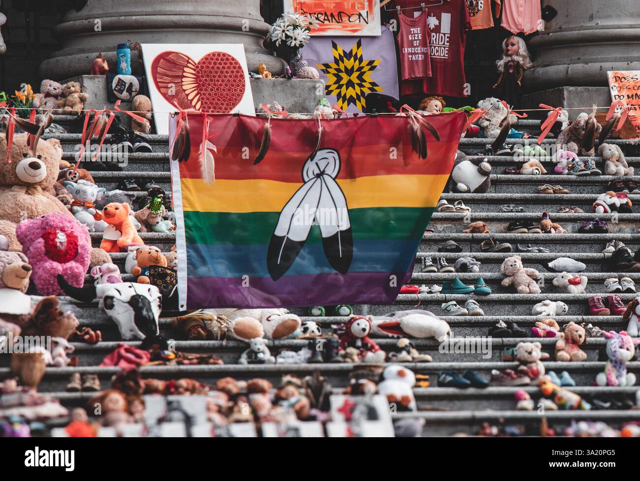 Vancouver, Canada - agosto 9,2021: Primo piano del memoriale indigeno alla Vancouver Art Gallery con una bandiera arcobaleno con piume d'aquila Foto Stock