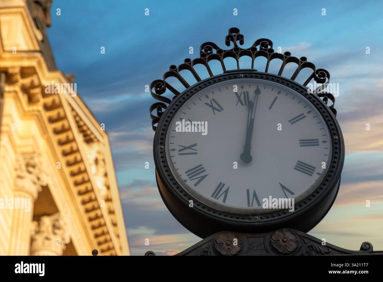 La torre dell'orologio mostra l'ora con i numeri romani su un cielo blu chiaro a Bucarest, Romania, che mostra l'elegante architettura della città. Foto Stock