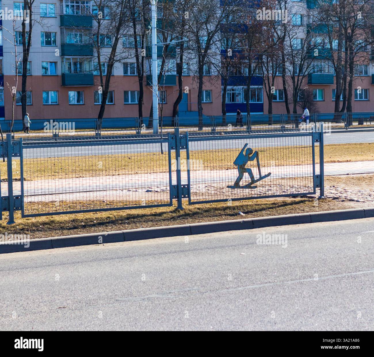 La recinzione separa il traffico bidirezionale con ornamenti decorativi legati allo sport Foto Stock