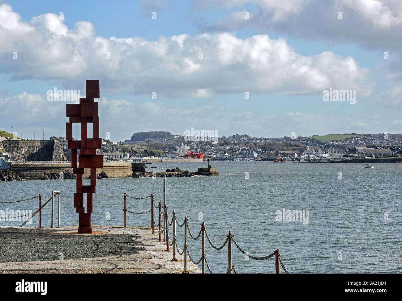 La scultura "Look II" di Sir Anthony Gormley si affaccia verso il Cattewater di Plymouth, dove l'AWH Alma è attraccata dalla sua casa sul West Hoe Pier PL Foto Stock
