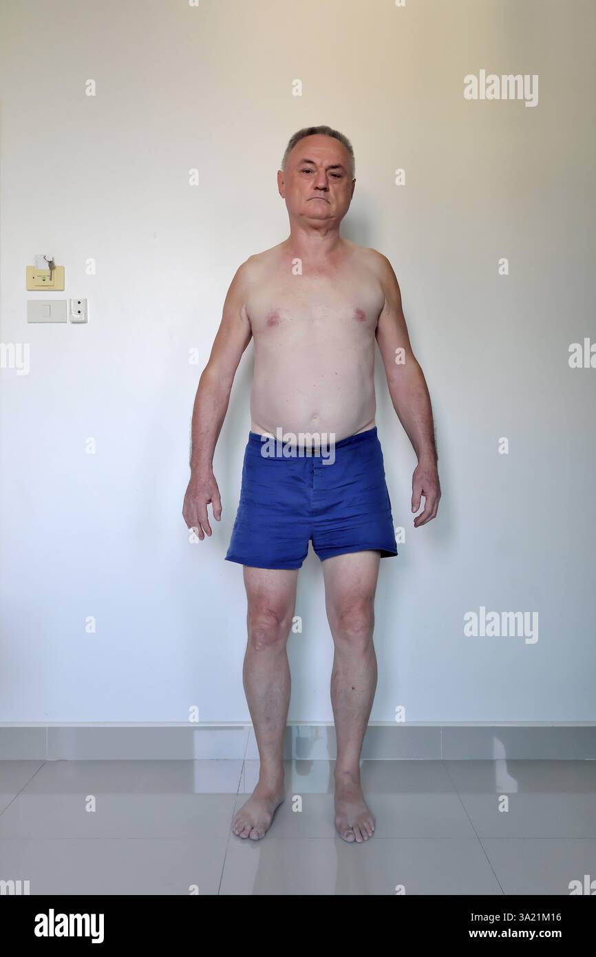 Uomo 60 Plus con pantaloncini da pugile davanti al muro bianco, Pattaya, Chonburi, Thailandia, Asia Foto Stock