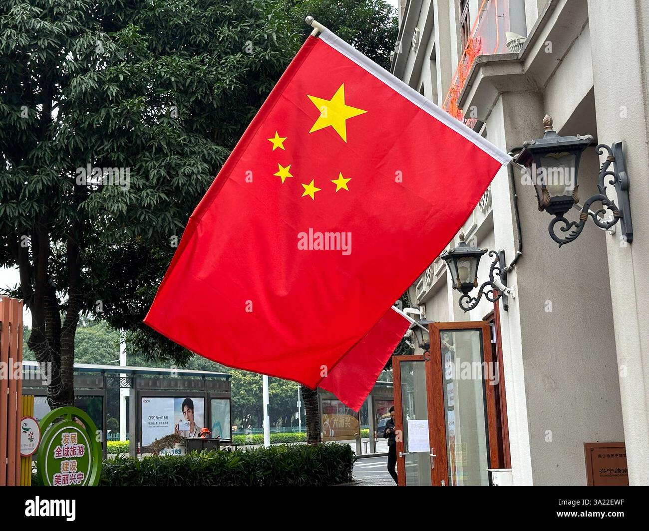 La bandiera nazionale della Cina fluttua nel vento contro un edificio Foto Stock