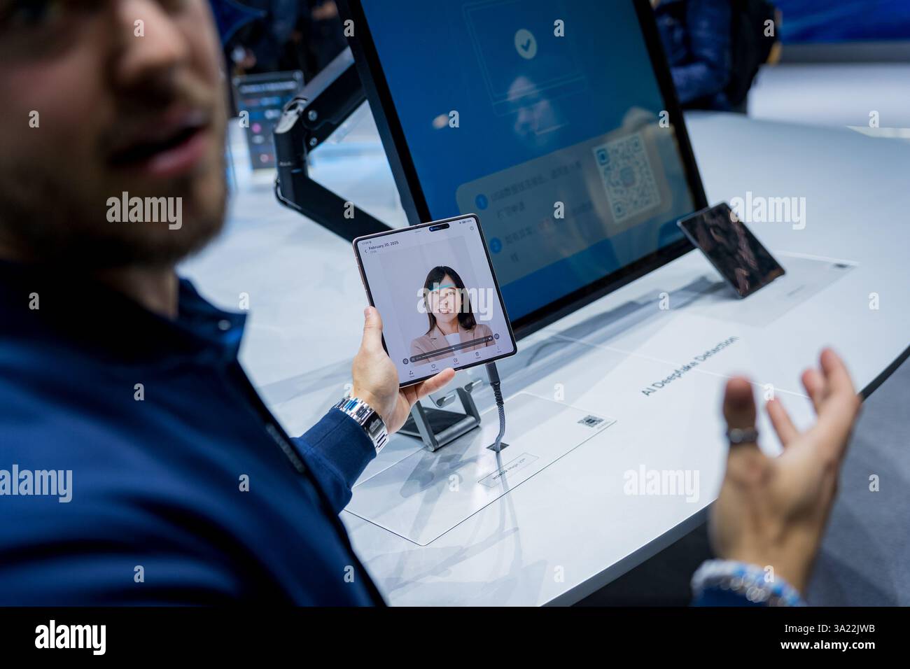 Barcellona, Spagna - 4 marzo 2025: Un assistente all'evento mostra una profonda tecnologia di riconoscimento falso al Mobile World Congress 2025 (MWC) presso la Fira de Ba Foto Stock