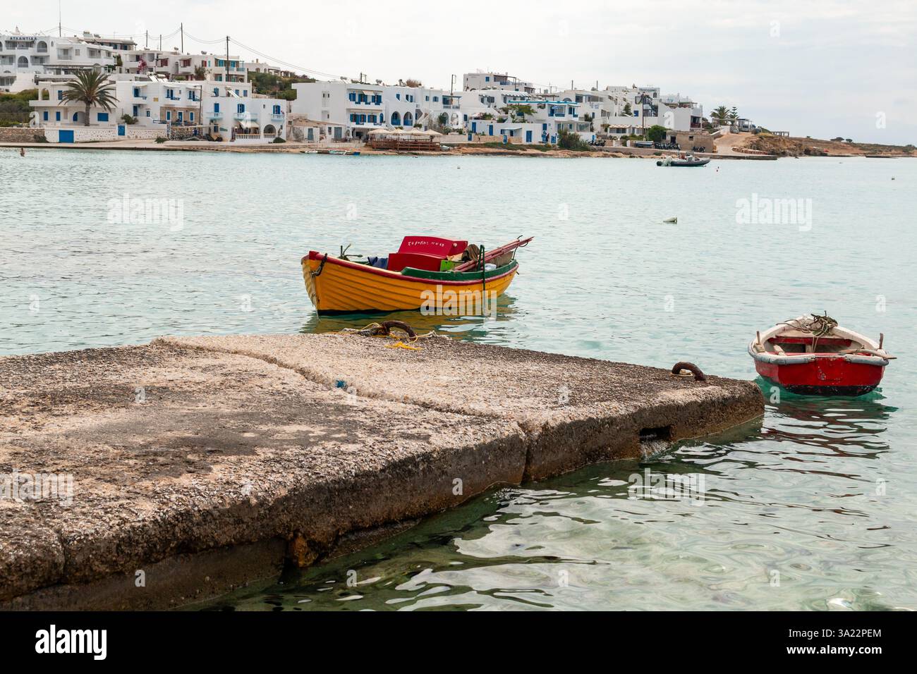 Barche a remi all'isola di Ano Koufonisi nelle Cicladi, Grecia. Tradizionali edifici bianchi della città principale di Chora sullo sfondo Foto Stock