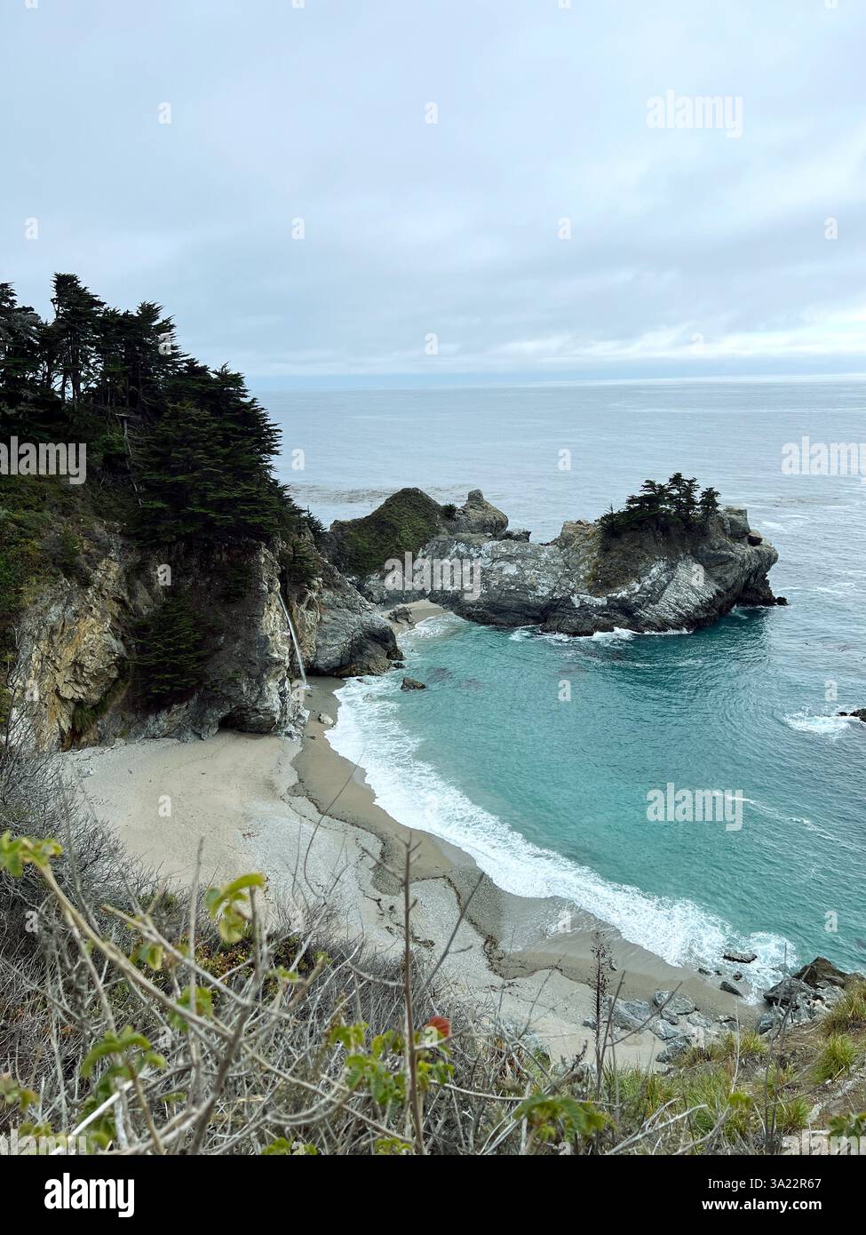 Veduta panoramica delle scogliere costiere di Big Sur, della spiaggia sabbiosa e delle onde calme con acque turchesi dell'Oceano Pacifico dal Julia Pfeiffer Burns State Park, California USA Foto Stock