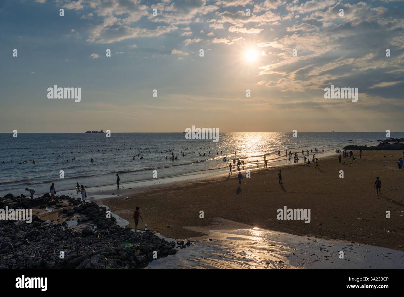 Si tratta di una spiaggia trafficata vicino al centro della città di Vung Tau durante il tramonto, un momento popolare per la gente del posto per andare a nuotare il 13 ottobre 2024 a Vung Tau, Vietnam Foto Stock