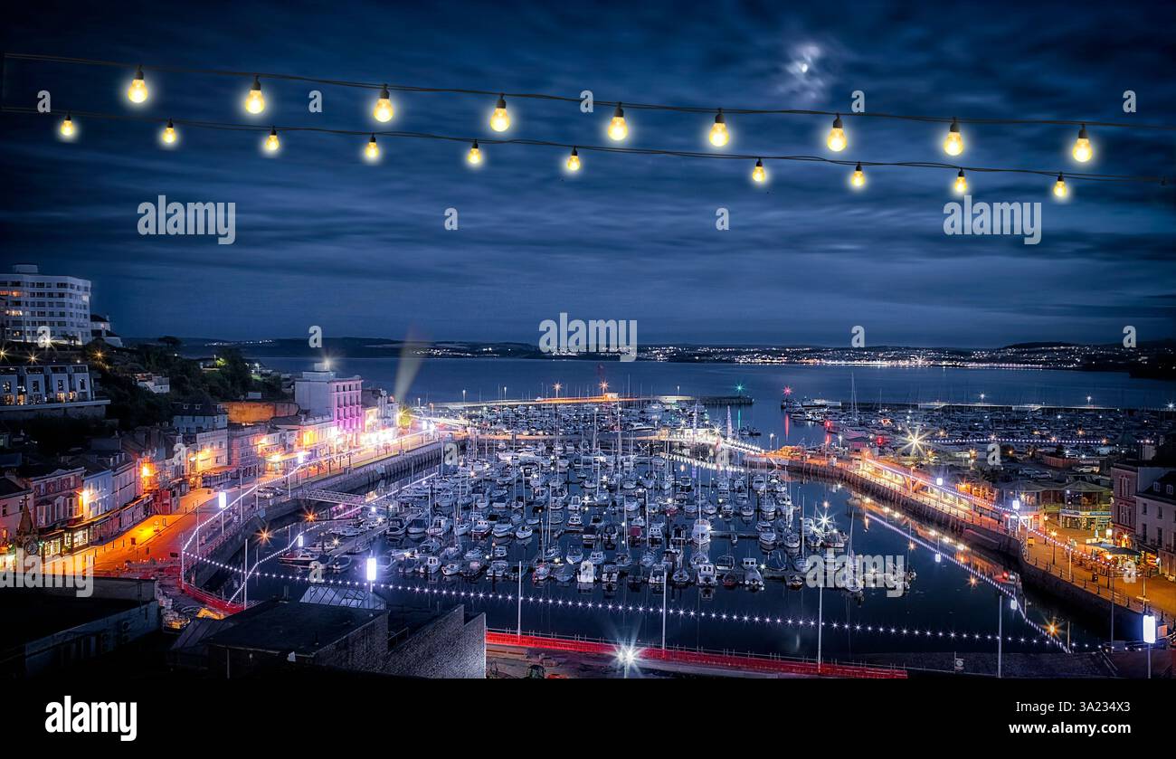 GB - DEVON: Vista notturna sulla baia di Tor con Torquay Harbour in primo piano e Paignton in secondo piano (fotografia di Edmund Nagele FRPS) Foto Stock