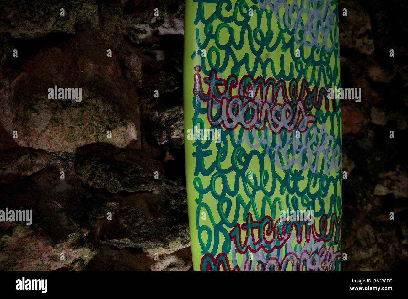 Una tavola da surf vibrante con intricate scritte in stile graffiti esposte all'interno del forte de São Miguel Arcanjo Foto Stock