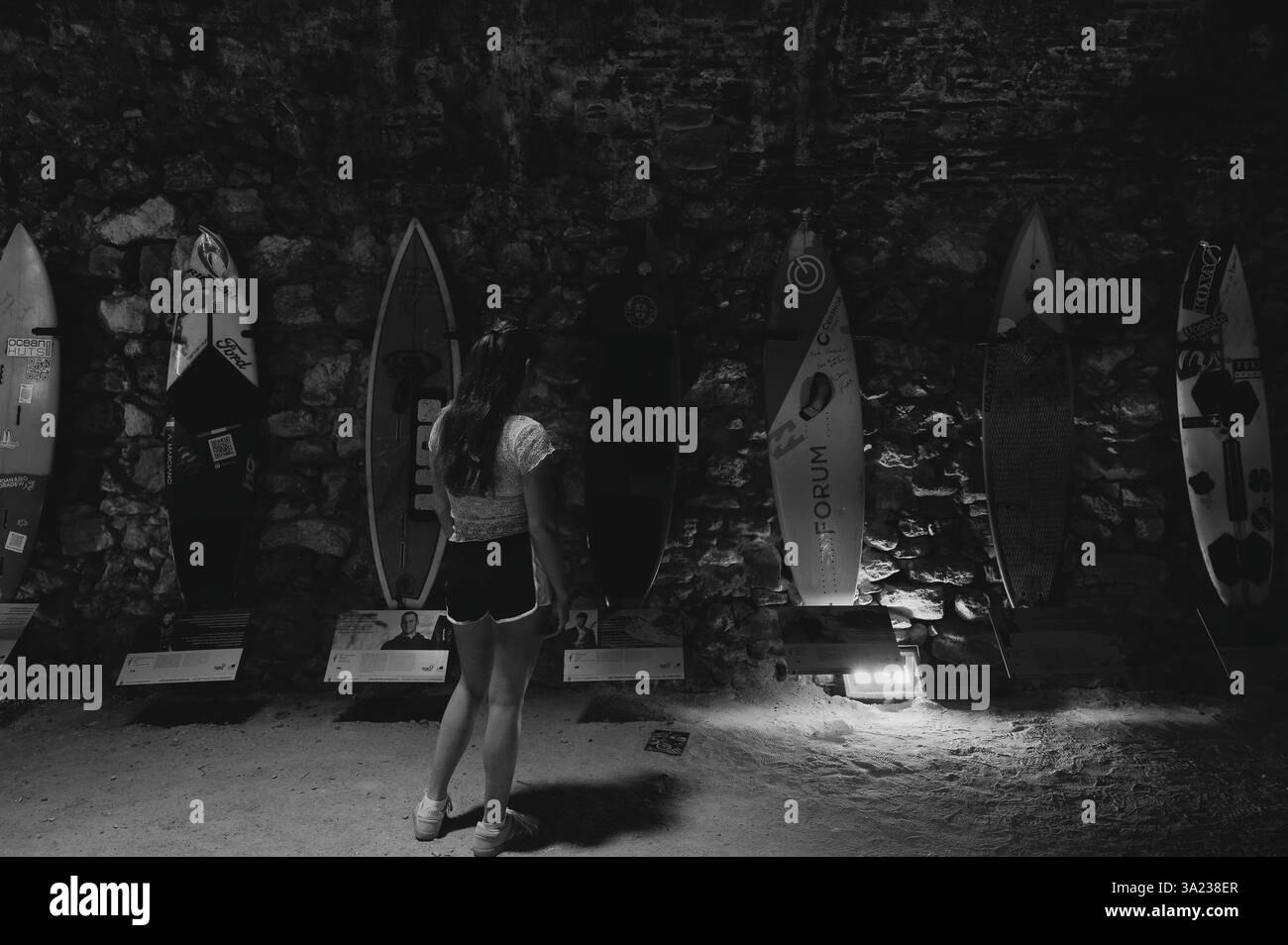I visitatori ammirano le tavole da surf esposte all'interno del forte de São Miguel Arcanjo a Nazaré Foto Stock