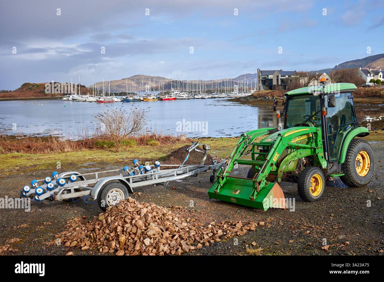A Craobh Haven Marine, un singolo trattore e rimorchio attendono il ritorno dell'operatore per continuare il lavoro. Craobh Haven, Argyll e Bute, Scozia Foto Stock