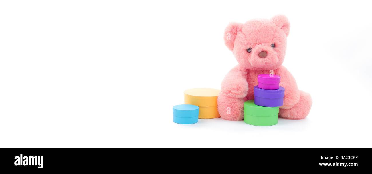 Simpatico orsacchiotto corallino rosa con un set di scatole multicolore su sfondo bianco puro con spazio per le copie del testo Foto Stock