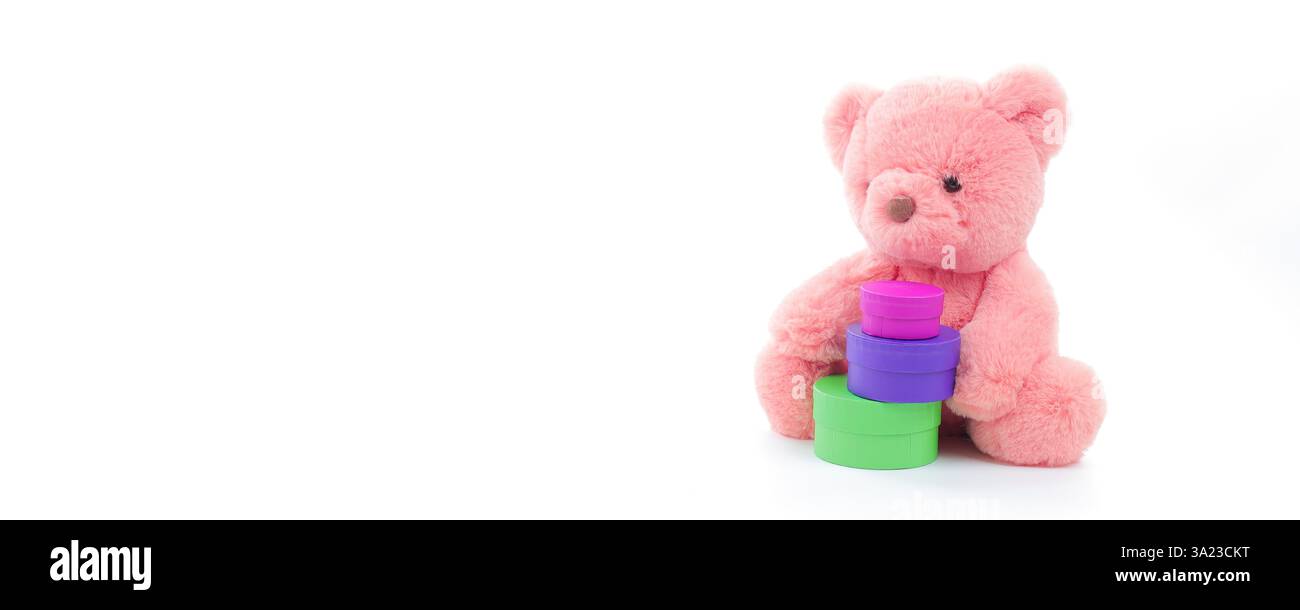 Simpatico orsacchiotto corallino rosa con un set di scatole multicolore su sfondo bianco puro con spazio per le copie del testo Foto Stock