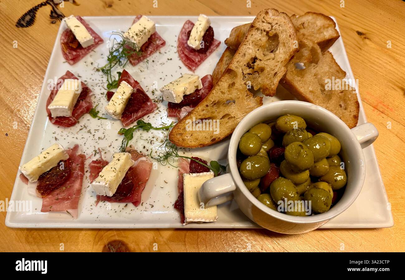 Olive, pane a pasta grossolana, formaggio e prosciutto. Tapas e Picos per due. Foto Stock