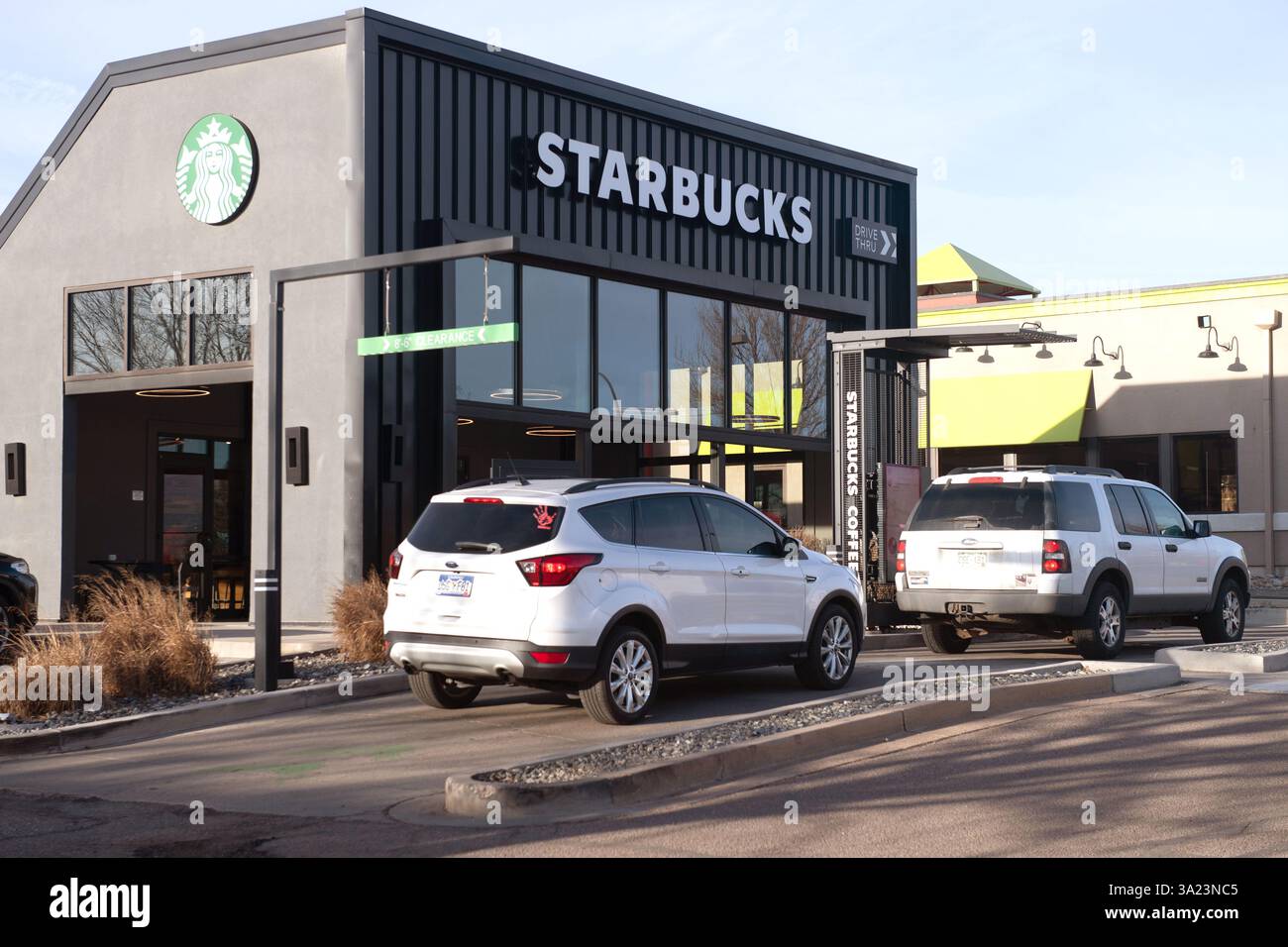 Le auto si allineano nella corsia Starbucks Drive Thru presso uno Starbucks a Colorado Springs, Colorado. La mattina presto in una giornata di lavoro. Foto Stock