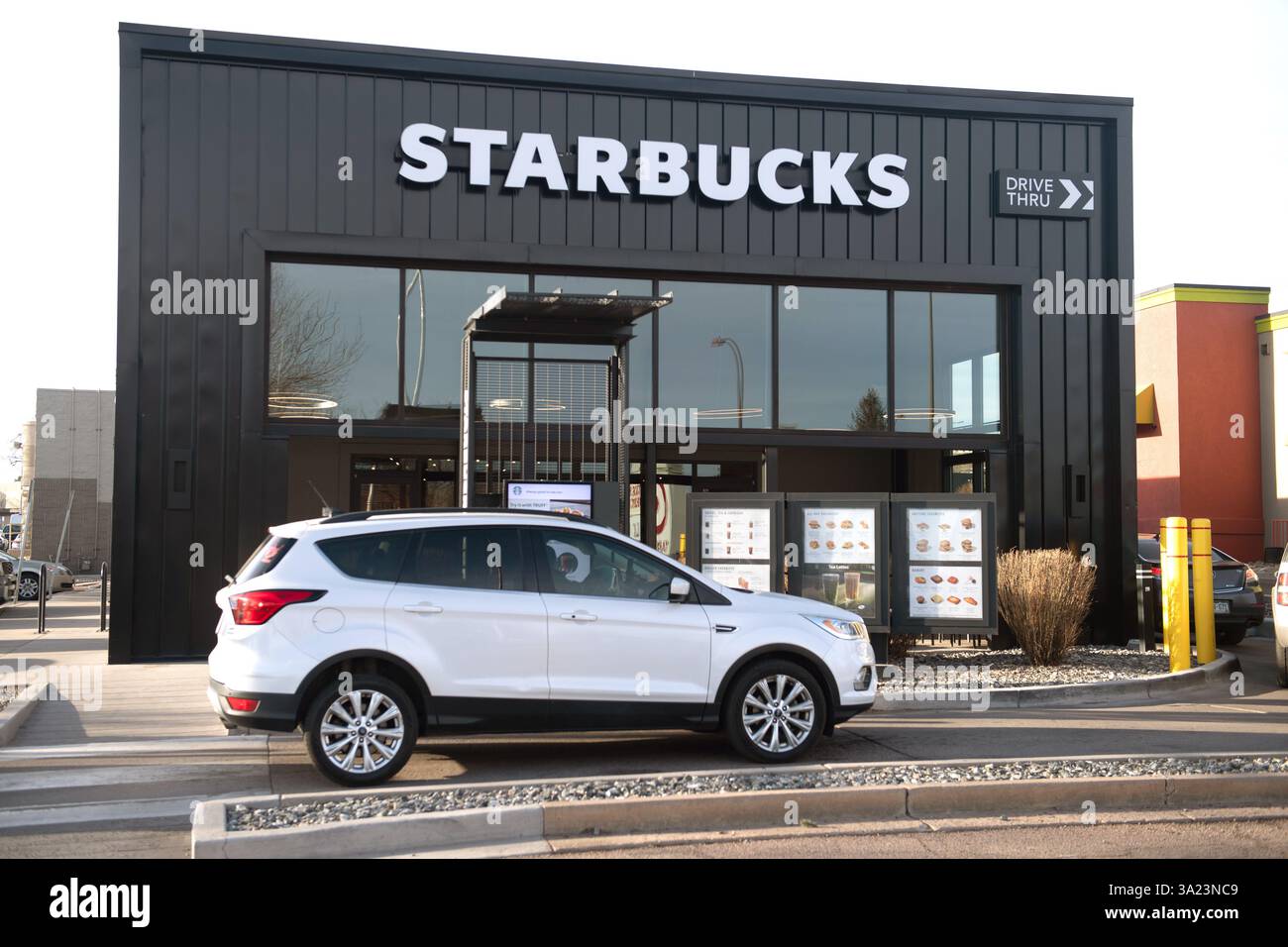 Le auto si allineano nella corsia Starbucks Drive Thru presso uno Starbucks a Colorado Springs, Colorado. La mattina presto in una giornata di lavoro. Foto Stock