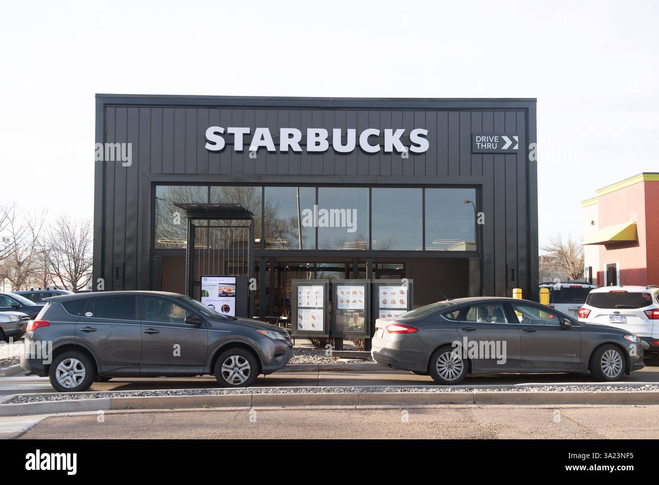 Le auto si allineano nella corsia Starbucks Drive Thru presso uno Starbucks a Colorado Springs, Colorado. La mattina presto in una giornata di lavoro. Foto Stock