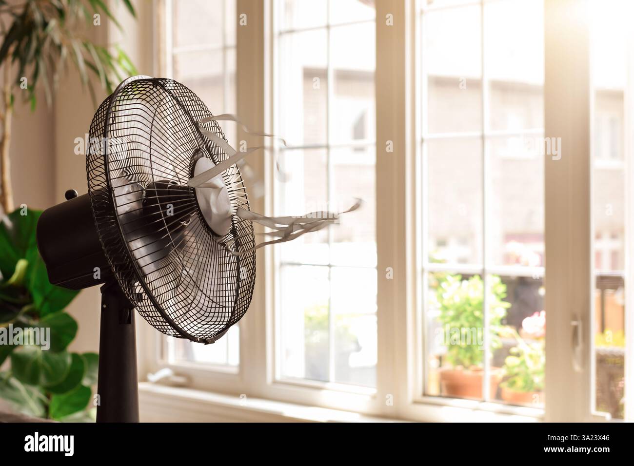 Ventola di raffreddamento elettrica con nastri soffianti davanti al finestrino nelle calde giornate estive Foto Stock