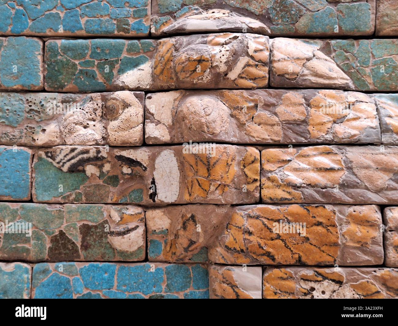 Primo piano dell'antico mosaico murale di una testa di leone della processione babilonese su sfondo turchese Foto Stock