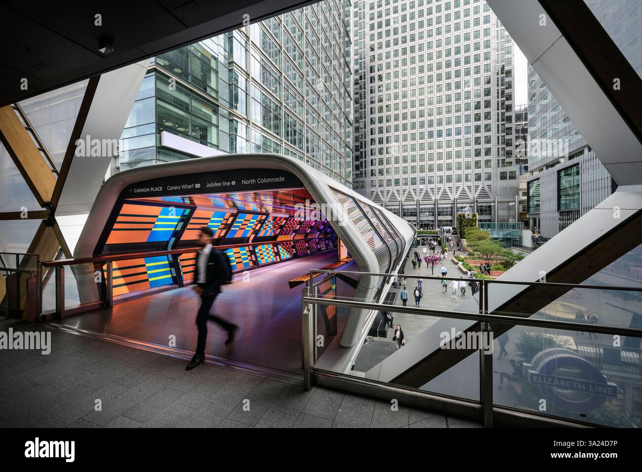 I pedoni camminano nel futuristico tunnel leggero tra Canary Wharf Station e Crossrail Place, Docklands, Tower Hamlets, Isle of Dogs, Londra, ING Foto Stock