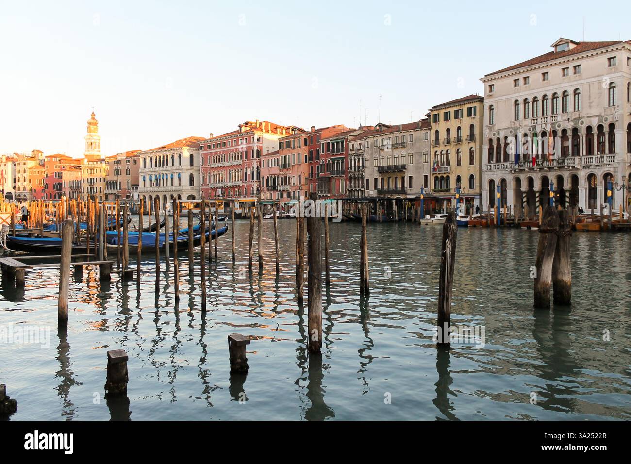 Una vista sul Canal grande a Venezia, Italia, al tramonto, con edifici storici che costeggiano il corso d'acqua, con gondole ormeggiate. Foto Stock