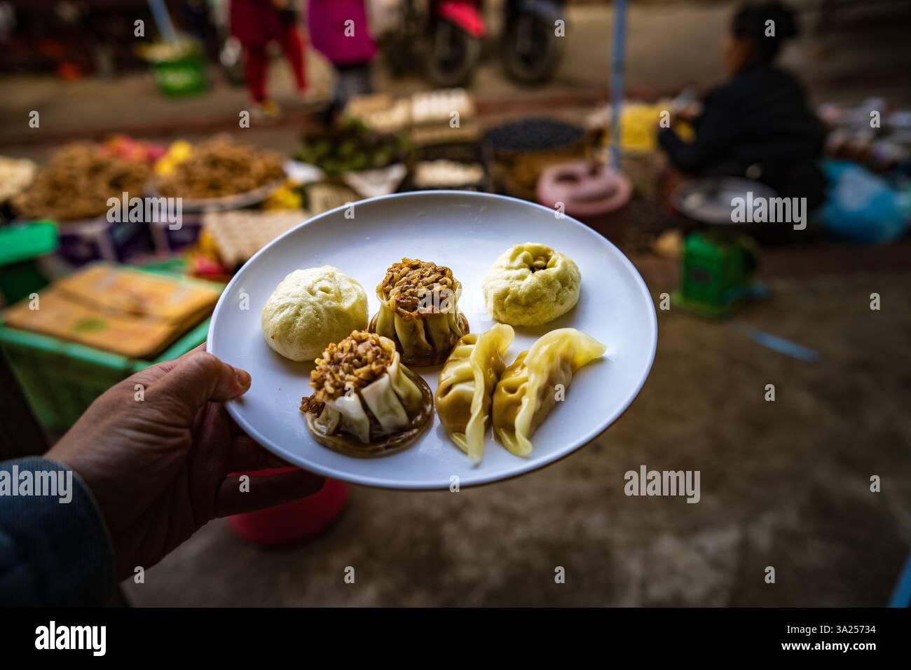Un piatto di gnocchi locali in un mercato in Asia. Questa immagine cattura la deliziosa varietà e la ricchezza culturale dello Street food Foto Stock