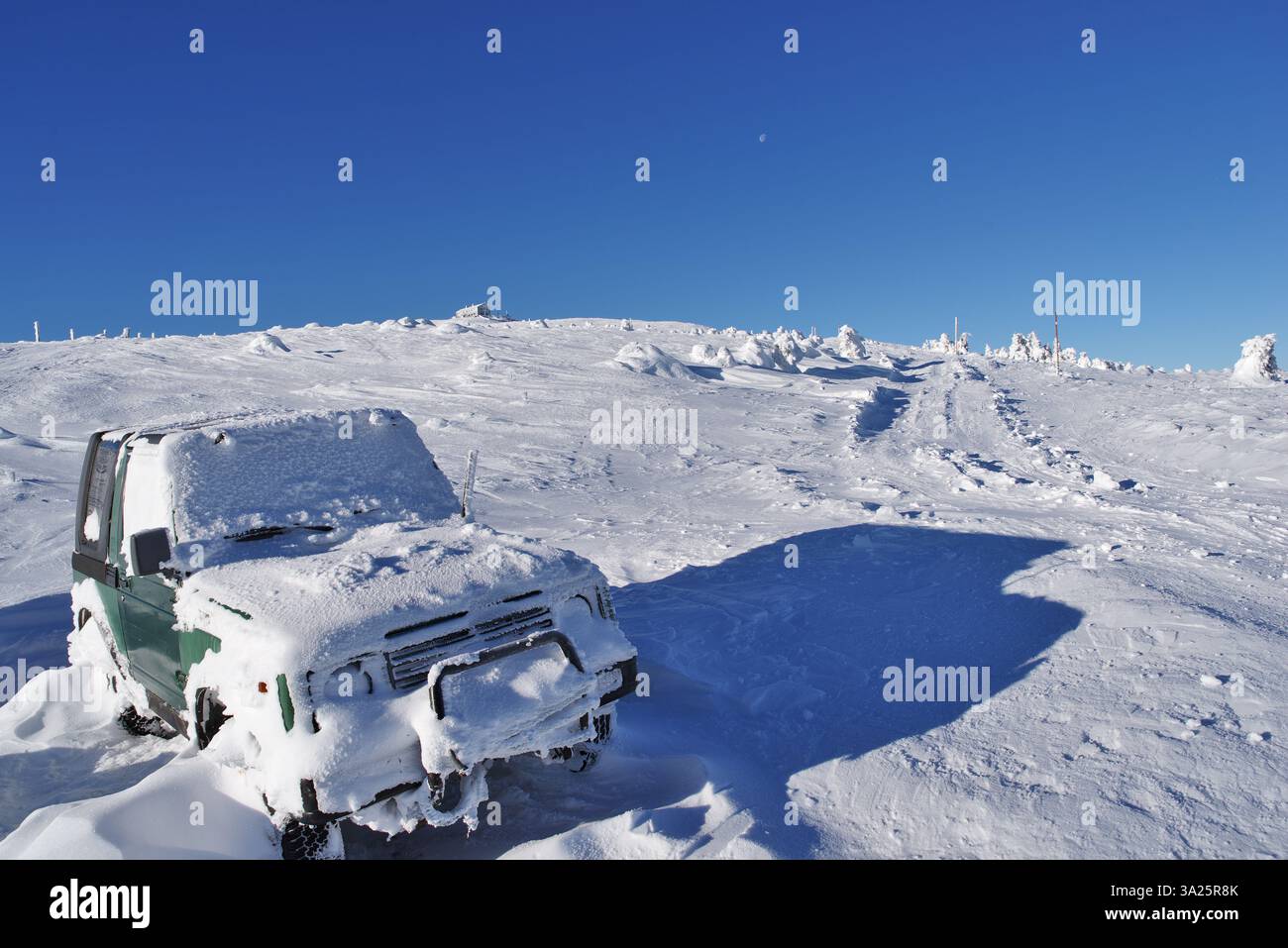 Soleggiato terreno fuoristrada invernale con strade alpine innevate e auto innevate. Foto Stock