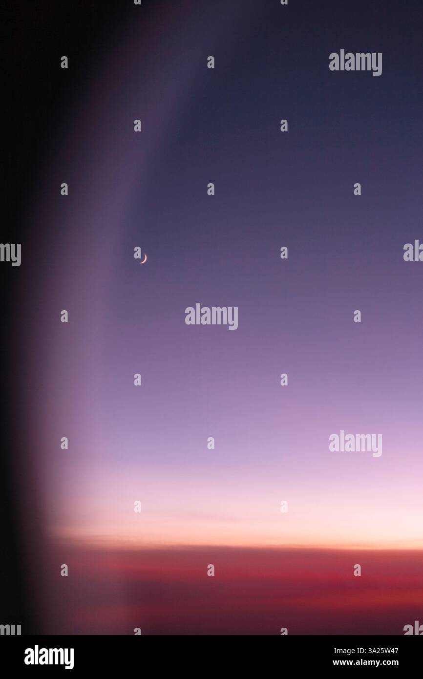 Vista della luna sottile dalla finestra del piano. Foto Stock