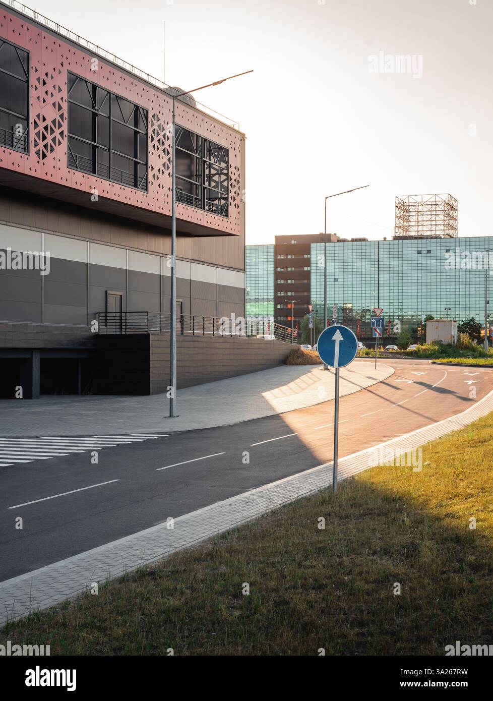 Strada nel nuovo quartiere con edifici moderni. Business center e magazzino al tramonto. Foto Stock
