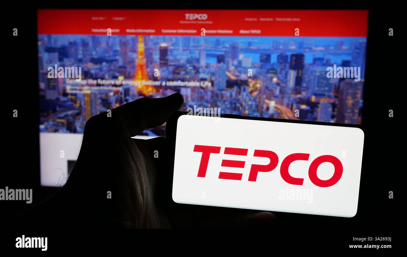In questa illustrazione fotografica, una persona ha in mano un telefono cellulare con il logo dell'azienda energetica Tokyo Electric Power Company (TEPCO) sullo schermo davanti alla pagina Web. (Foto di Timon Schneider / SOPA Images/Sipa USA) *** esclusivamente per notizie editoriali *** Foto Stock