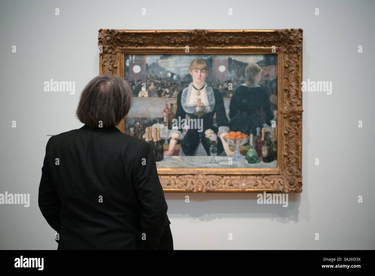 Un visitatore studia "A Bar at the Folies-Begère" di Manet alla Cortauld Gallery di Londra Foto Stock