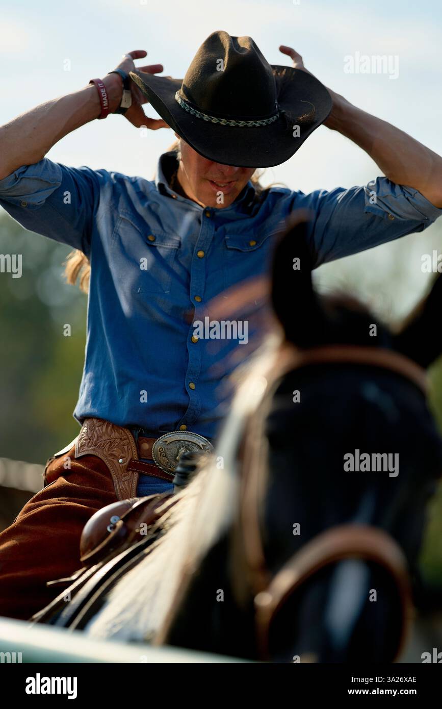 Cowgirl e cowboy country e western uomo e donna con il cavallo e la sella sulla fattoria, ranch Foto stock