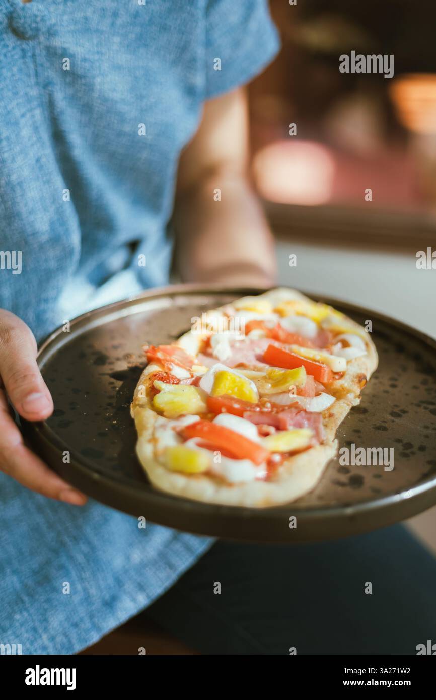 Piccola pizza hawaiana tagliata e servita, focus selettivo Foto Stock