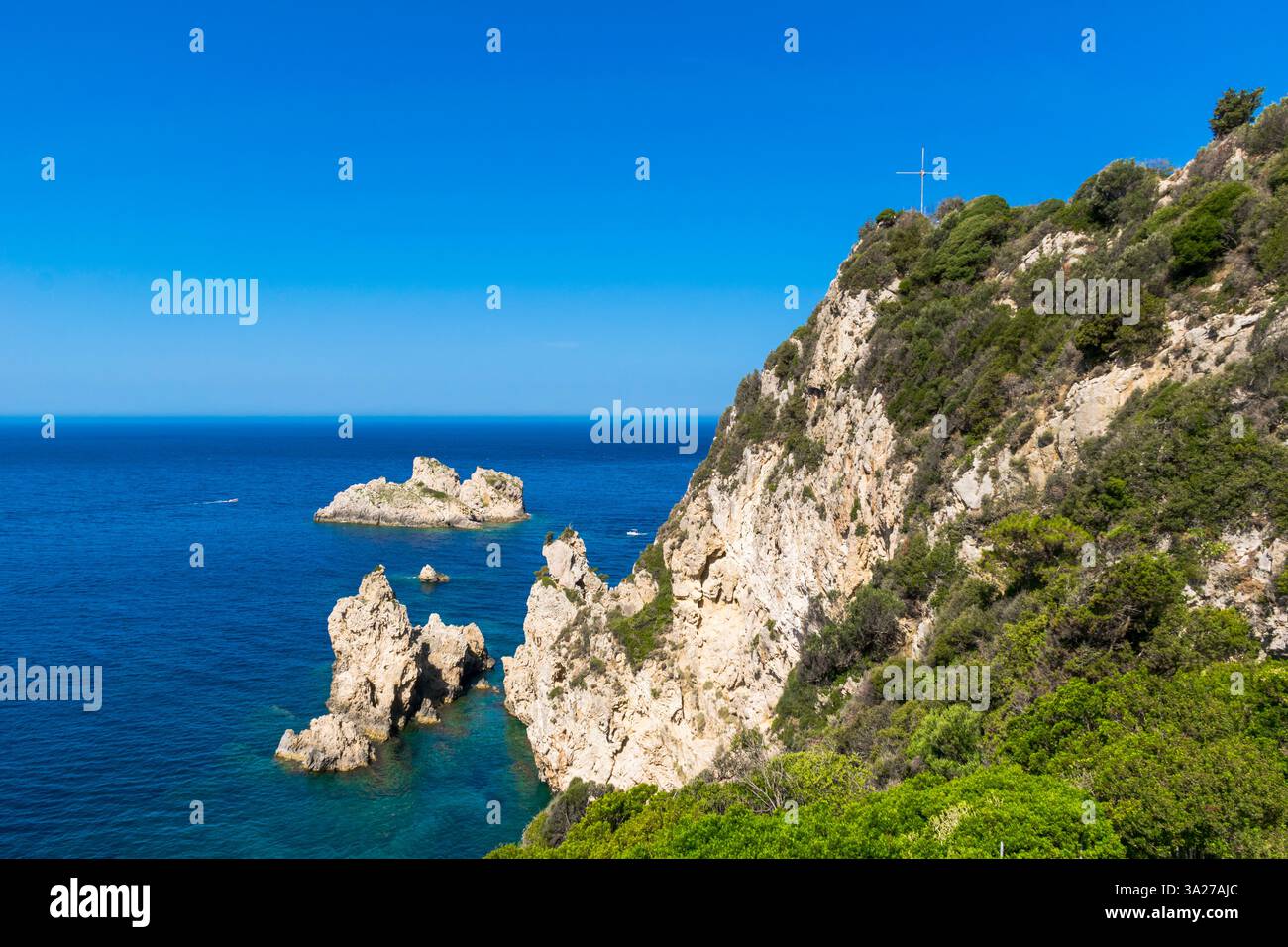 Vista panoramica della costa rocciosa di Corfù con croce bianca in cima a Palaiokastritsa, Grecia Foto Stock