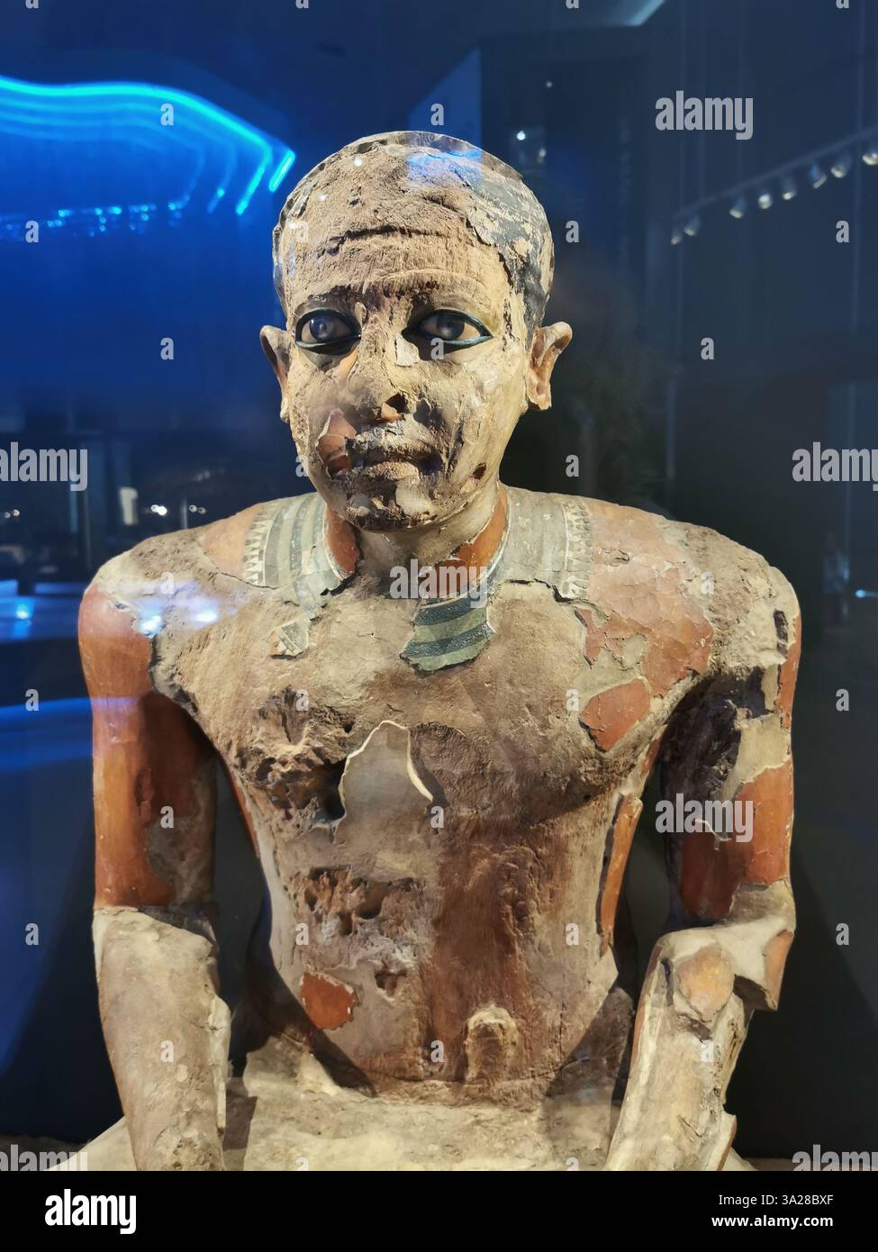 Statua realistica a gambe incrociate con occhi inquietanti, il Grand Egyptian Museum, il Cairo, scultura realistica del Vecchio Regno, arte egizia antica Foto Stock