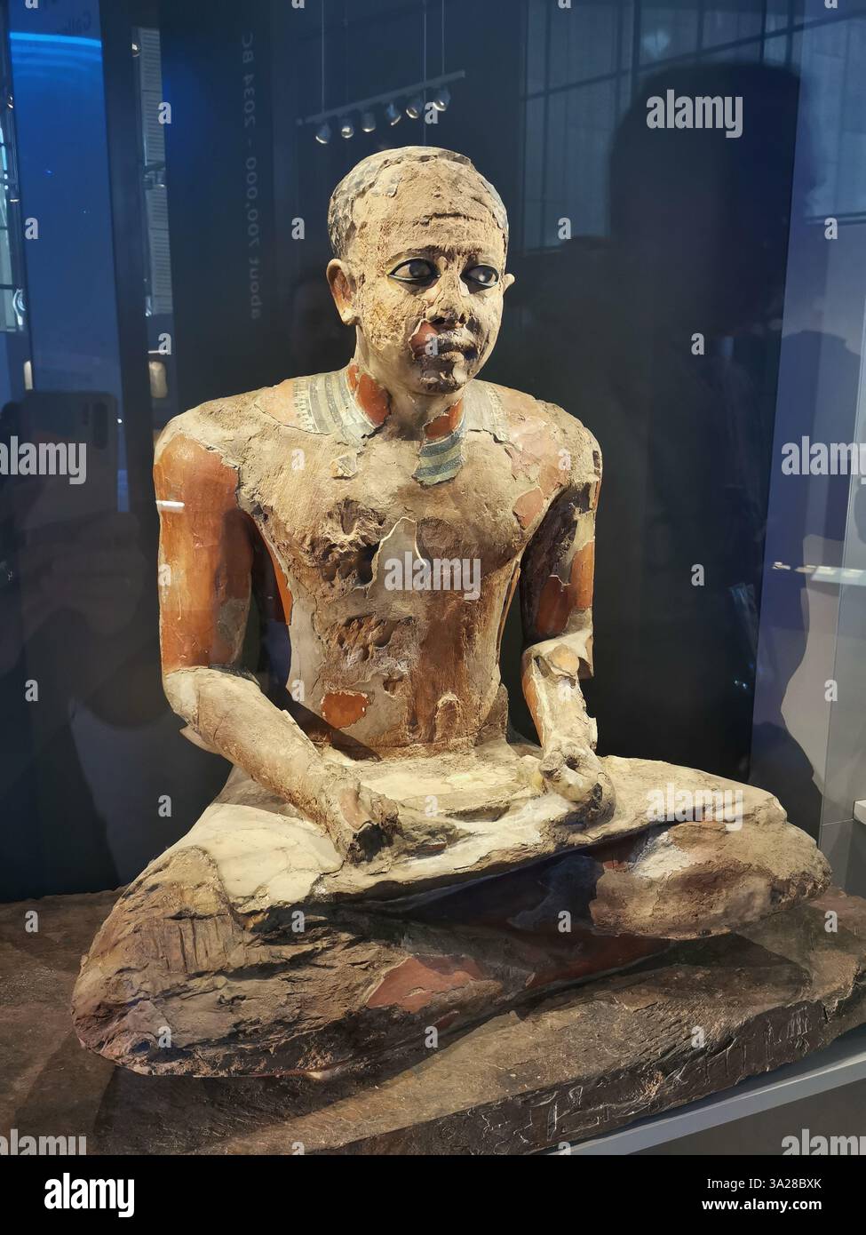 Statua realistica a gambe incrociate con occhi inquietanti, il Grand Egyptian Museum, il Cairo, scultura realistica del Vecchio Regno, arte egizia antica Foto Stock