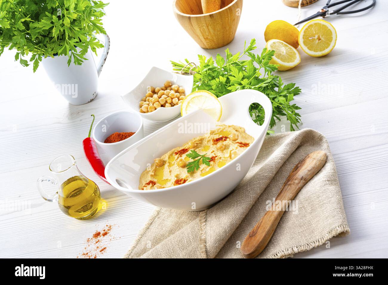 Pasta di hummus con limone e peperoncino su sfondo bianco Foto Stock