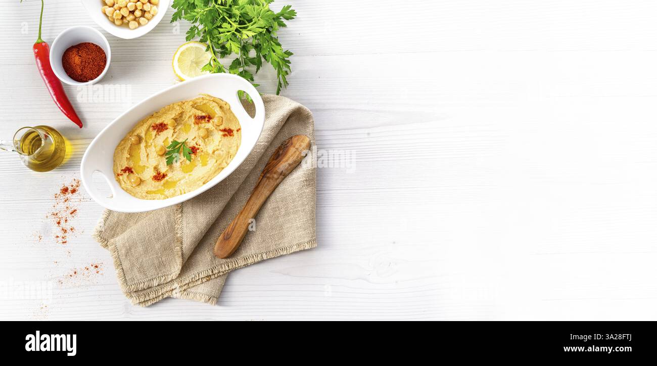 Pasta di hummus con limone e peperoncino su sfondo bianco Foto Stock