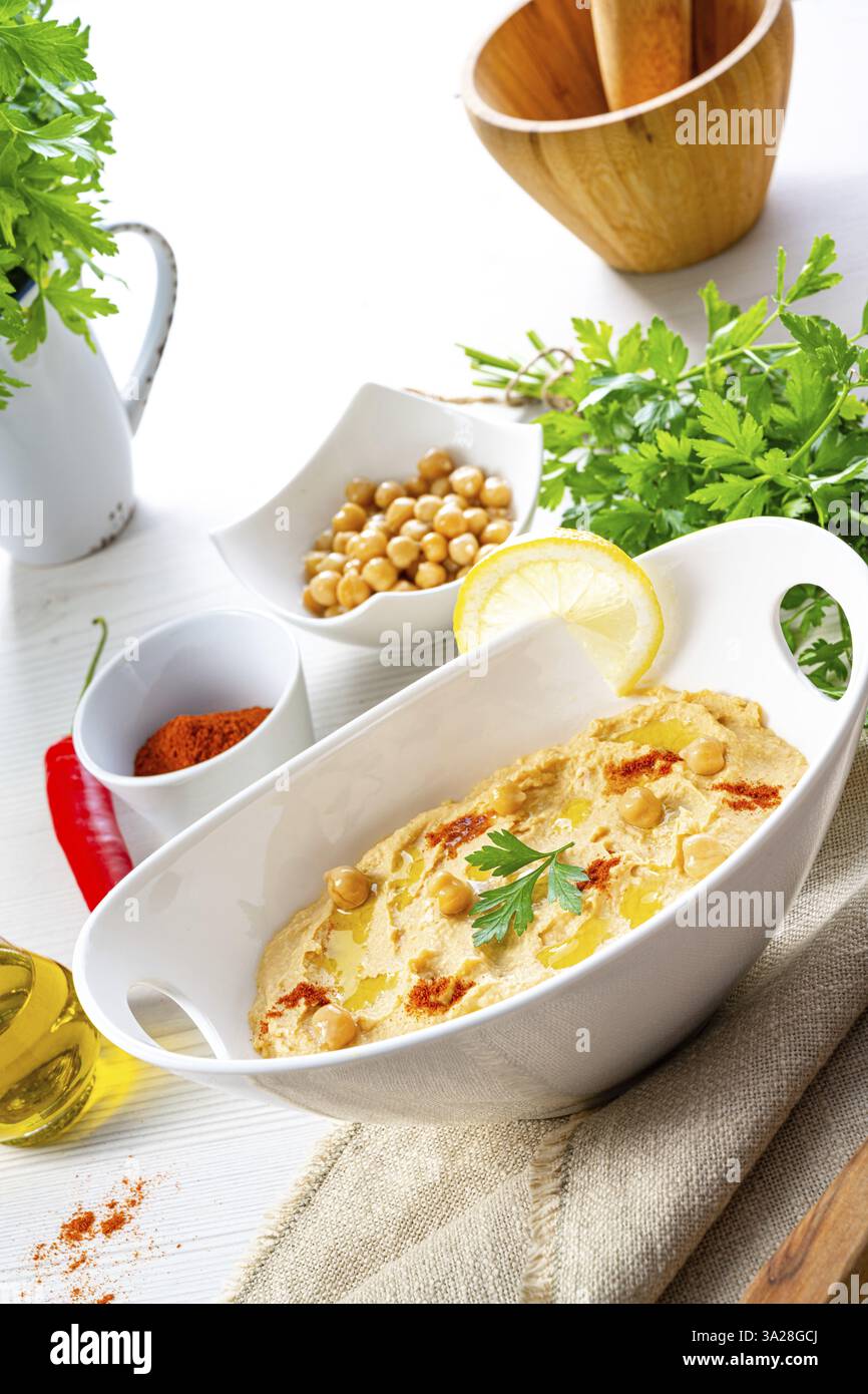 Pasta di hummus con limone e peperoncino su sfondo bianco Foto Stock