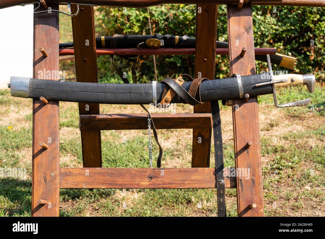 Sciabola ungherese del XVII secolo in fodera di pelle nera su piedistallo in legno Foto Stock