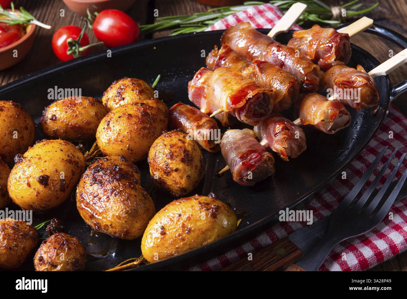Datteri rustici avvolti in pancetta e patate arrosto giovani Foto Stock
