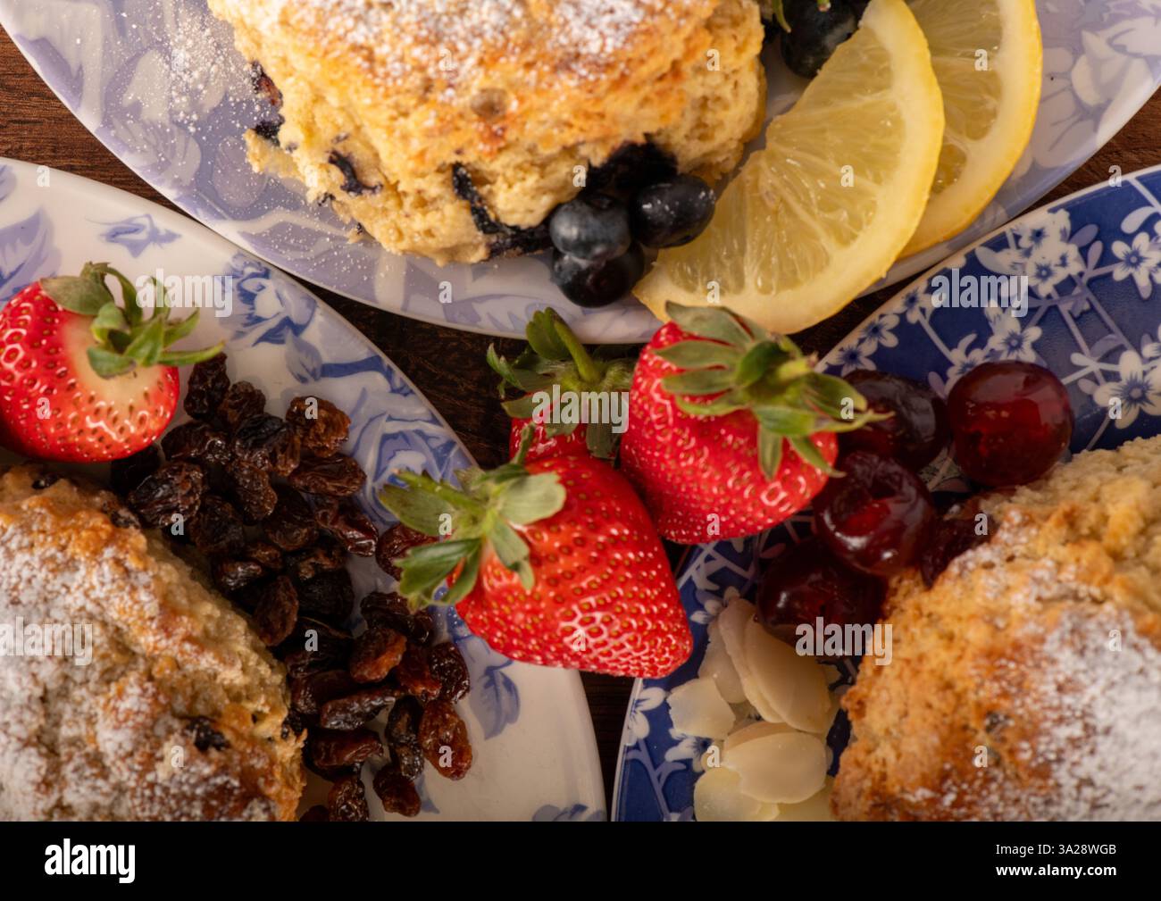 Tre piatti con fragole, mirtilli e fette di limone. I piatti sono disposti in modo da rendere il cibo appetitoso e inviti Foto Stock