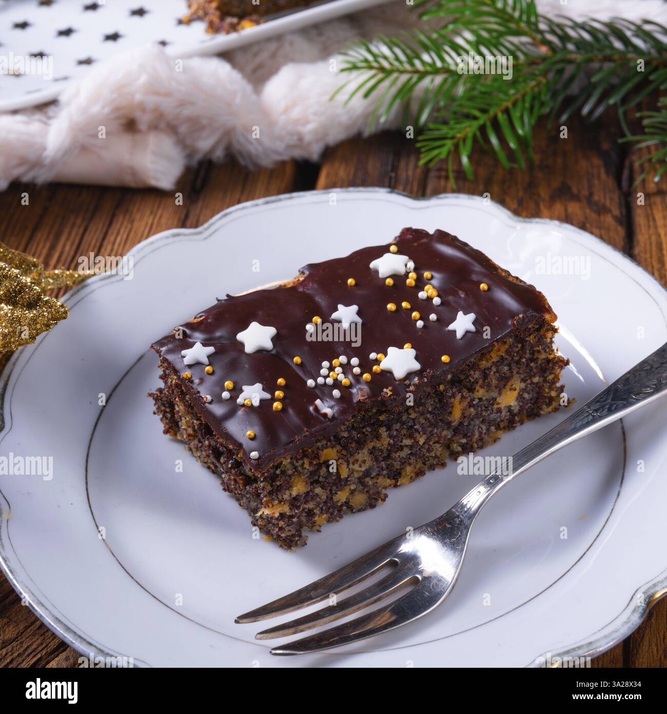Torta natalizia con semi di papavero con cioccolato, noci e uva sultanina Foto Stock