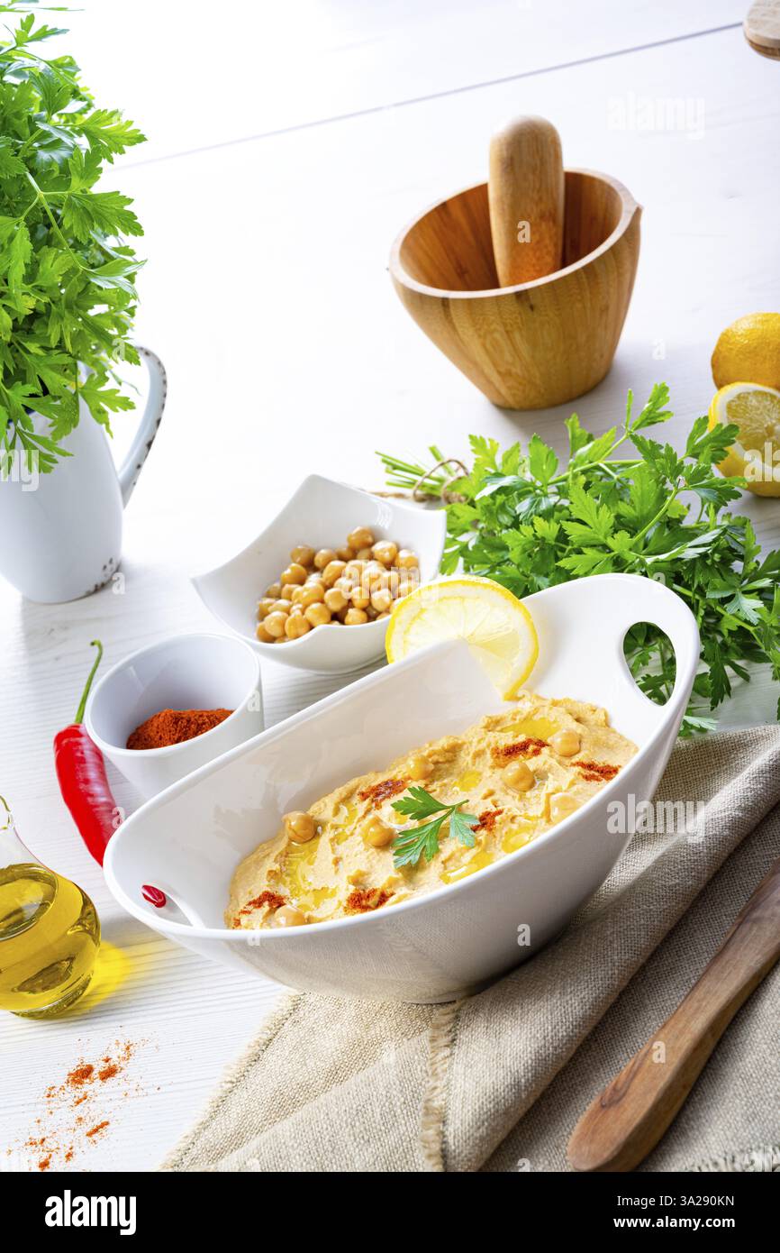 Pasta di hummus con limone e peperoncino su sfondo bianco Foto Stock