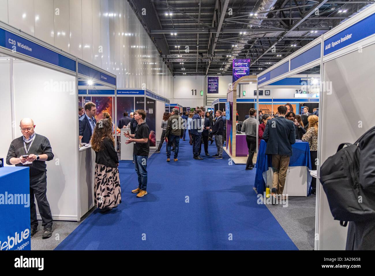 Persone che esplorano le bancarelle e le mostre allo Space Comm Expo 2025 presso l'Excel Centre di Londra, Regno Unito Foto Stock