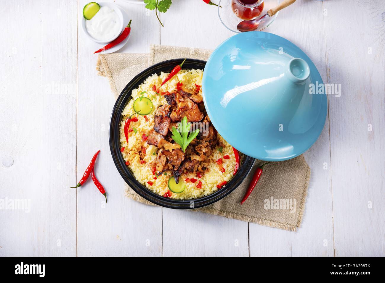 Tajin con couscous, verdure e carne su sfondo bianco Foto Stock