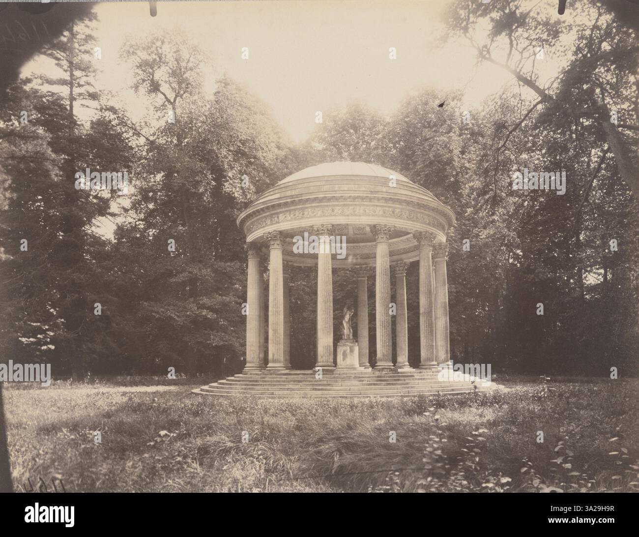 Il Grand Trianon, mostrato qui in questa fotografia, è una struttura di spicco nella Reggia di Versailles. Atget cattura la sua architettura classica e i giardini circostanti, riflettendo il suo significato storico come rifugio reale. Foto Stock