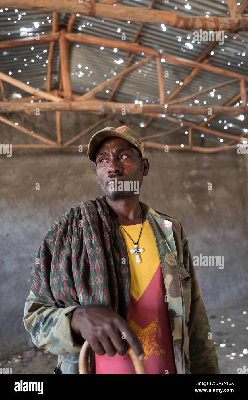 ETIOPIA, Distretto Yechila, villaggio SHEWEATE HUGUM, distrutto scuola durante la guerra Tigra 2020-2022 tra le forze alleate al governo federale etiope e l'Eritrea e il fronte di Liberazione del popolo Tigray TPLF, combattente TPLF / Äthiopien, Tigray, Folgen des Tigray Krieges 2020-2022, Distrikt Yechila, Dorf SHEWEATE HUGUM, zerstörte Schule, Gerse Tadese, Tigrayischer Kämpfer der TPLF, 51 Jahre alt, Sein Sohn ist im Krieg gefallen mit 22 Jahren, Gewehr Einschüsse Foto Stock